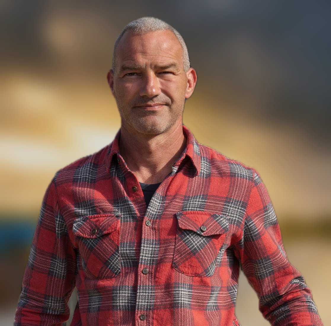 Dieter Ahlers, lächelnd vor warmem Sonnenuntergangs-Hintergrund